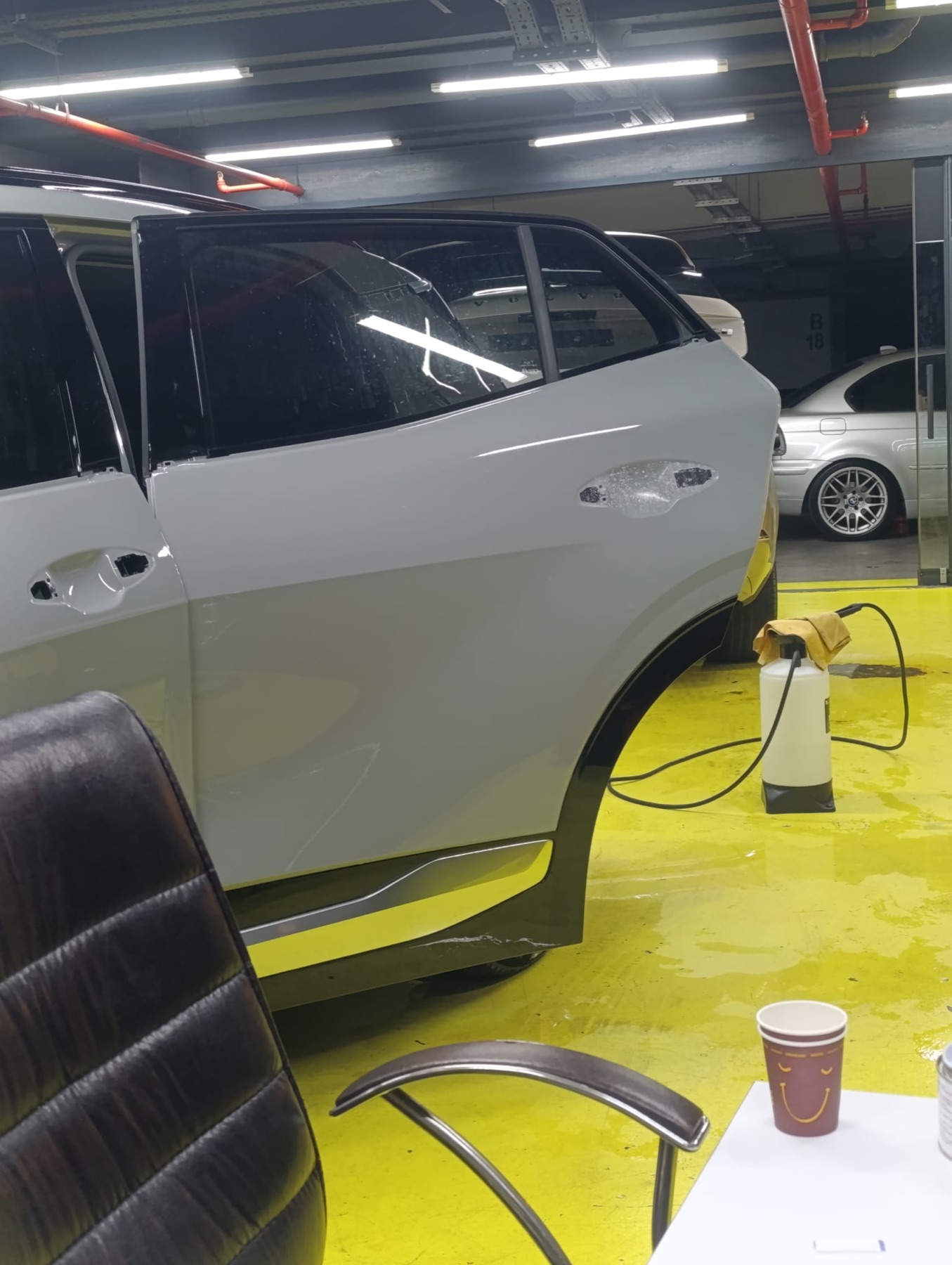 Beyaz BMW'nin yan kapı ve marşpiyel bölgesinde koruma filmi uygulaması