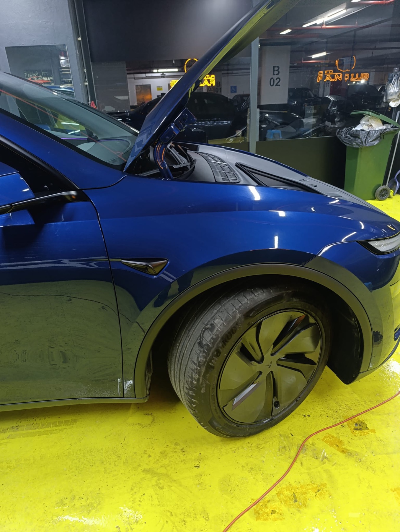 Mavi Tesla Model Y'nin ön çamurluğuna PPF kaplama uygulanıyor